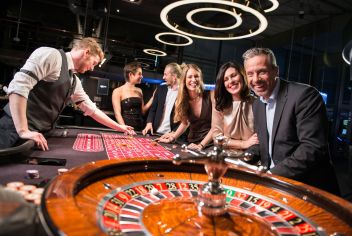 Einige Casino-Besucher haben sich an einem Roulette-Kessel versammelt